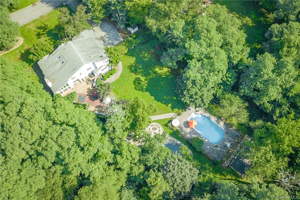 an aerial view of residential house with outdoor space and trees all around