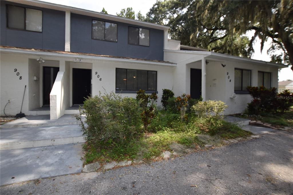 a front view of house with yard and trees around