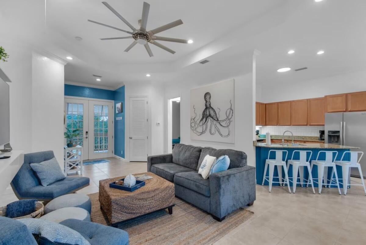 a living room with furniture kitchen view and a large window