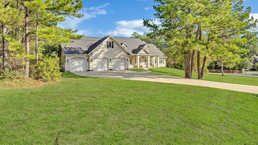 a view of a big house with a big yard and large trees