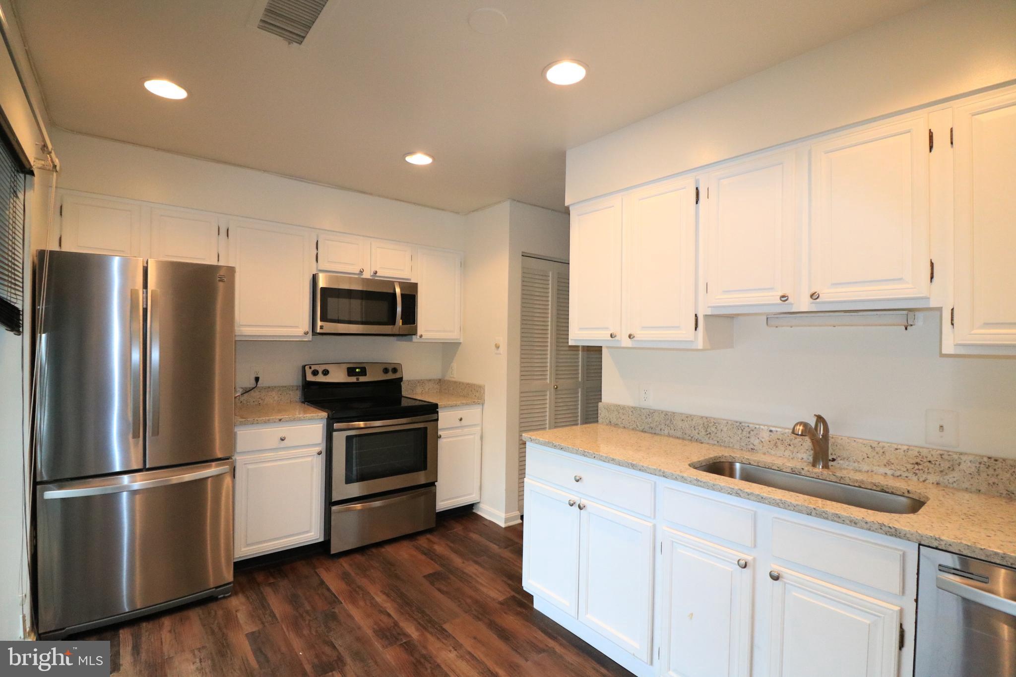 a kitchen with stainless steel appliances a refrigerator sink and microwave