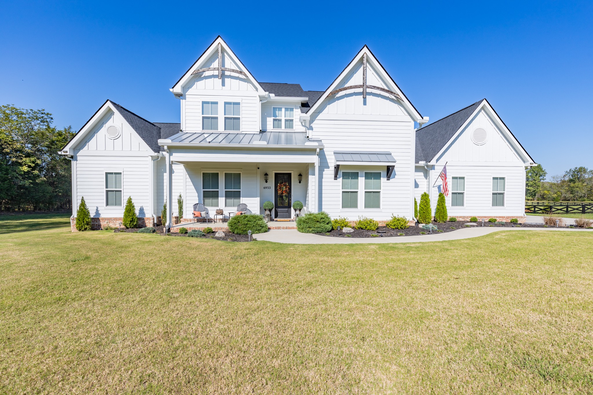 a view of house that has a yard and large trees in front of it