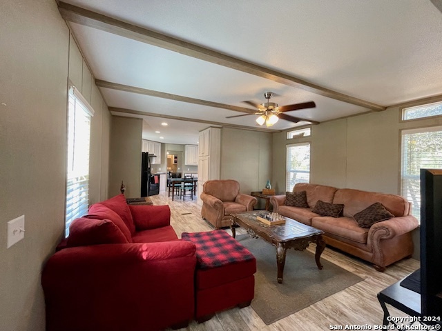 a living room with furniture a ceiling fan and a window