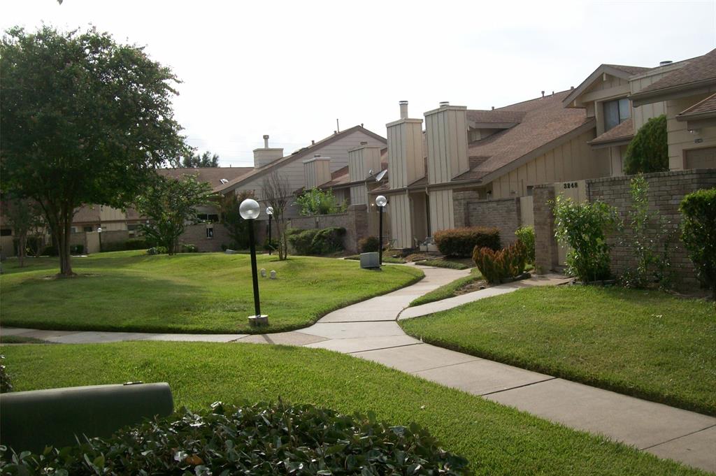 a view of a big house with a big yard and potted plants