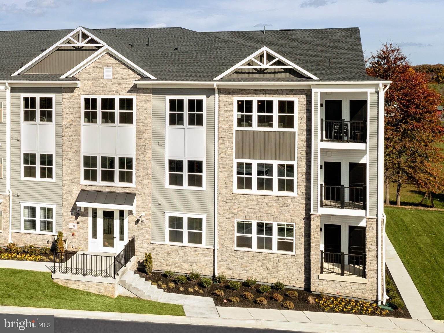 a front view of a residential apartment building with a yard