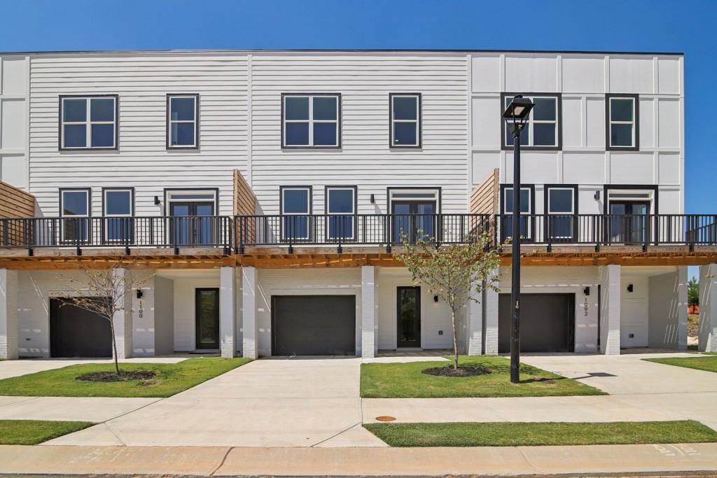 a front view of a house with yard and parking