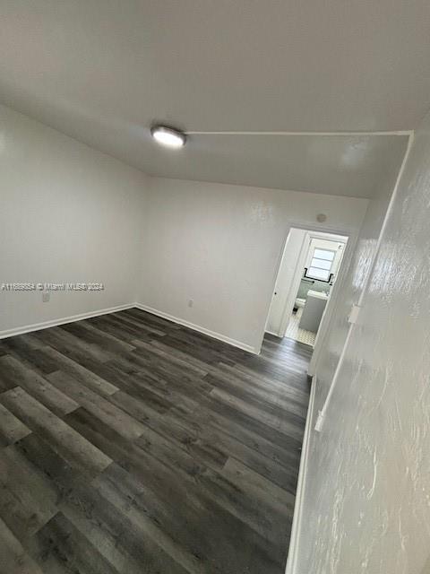 en empty room with wooden floor and window