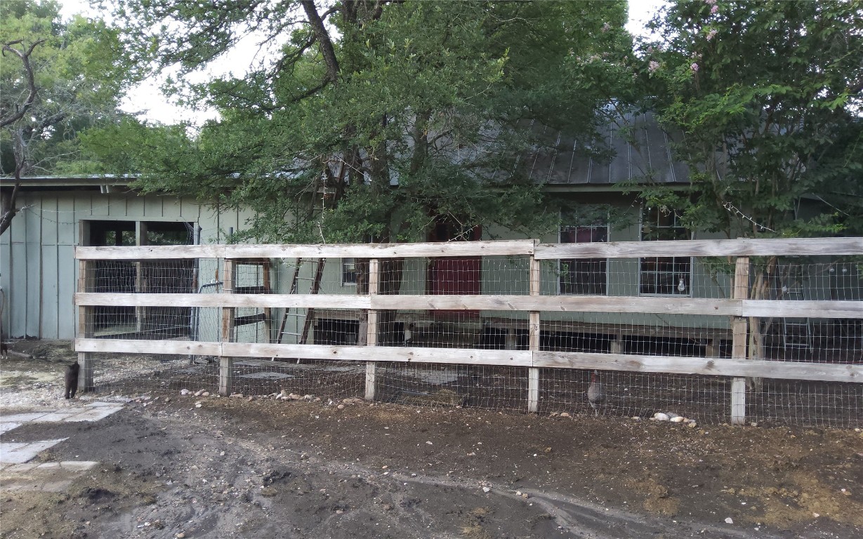 a view of a house with a large window and wooden fence