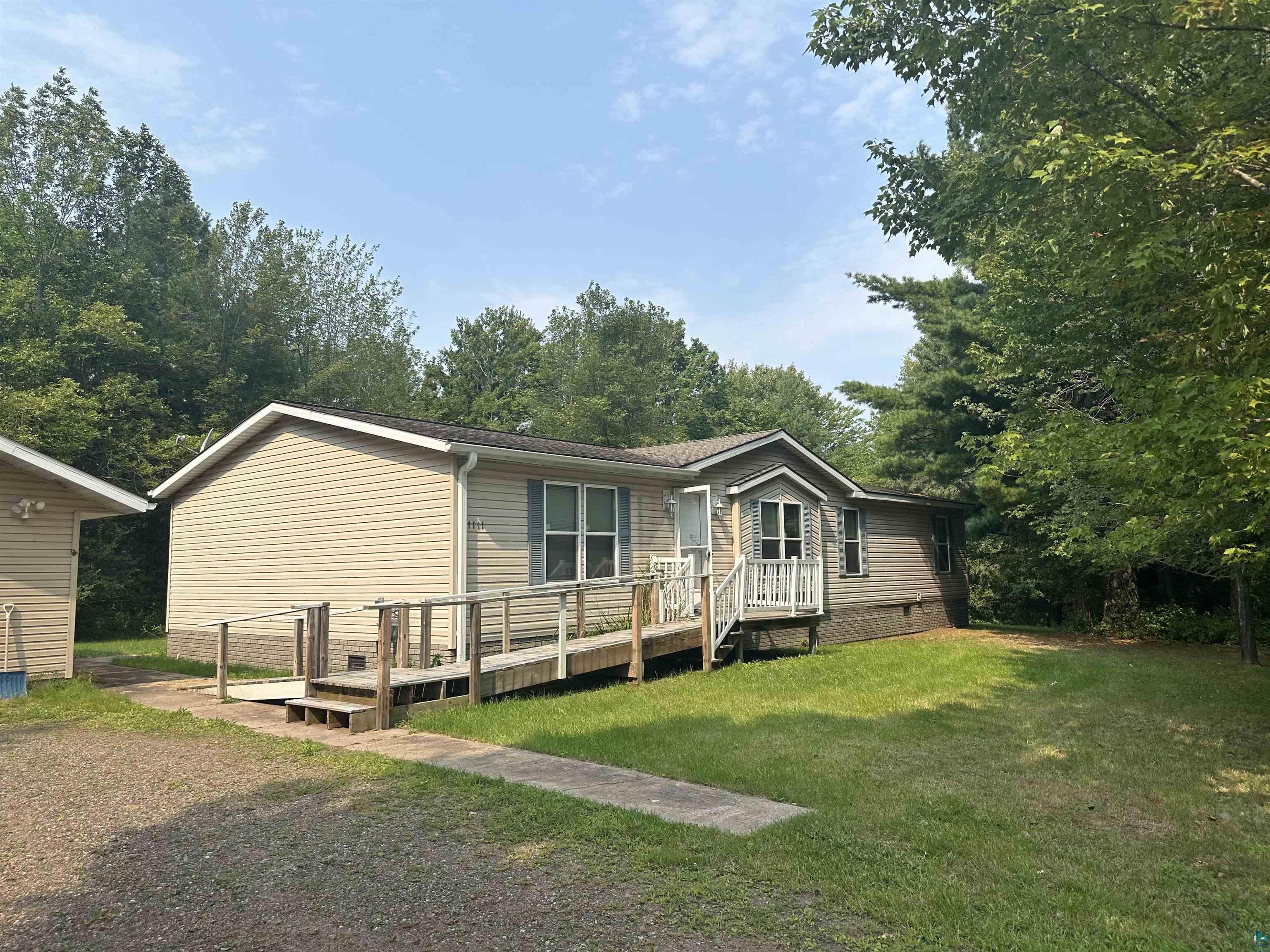 View of front facade with a front lawn and a wooden deck