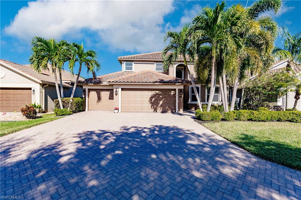 a front view of a house with a yard and palm trees