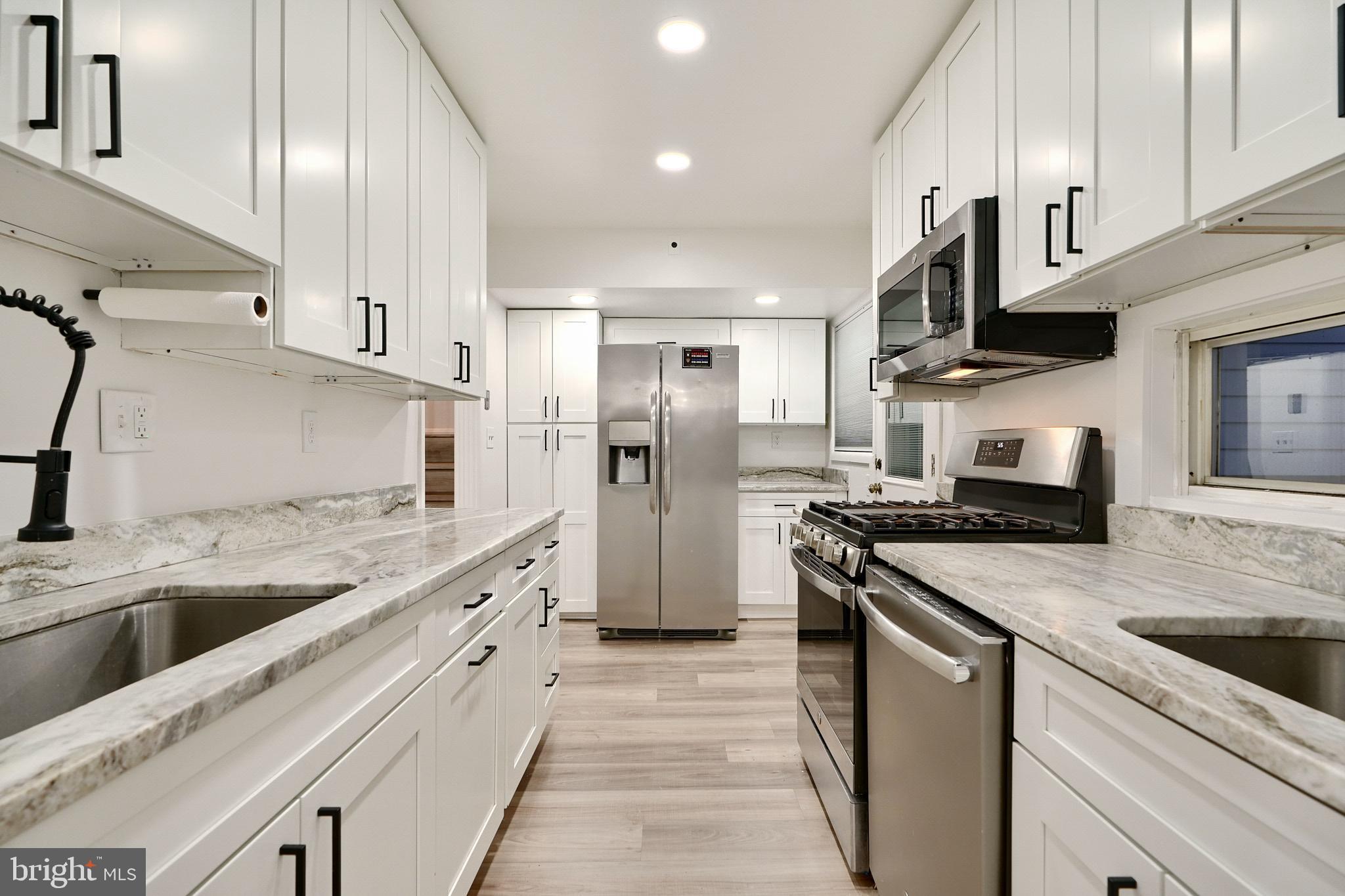 a kitchen with stainless steel appliances granite countertop a sink stove and refrigerator