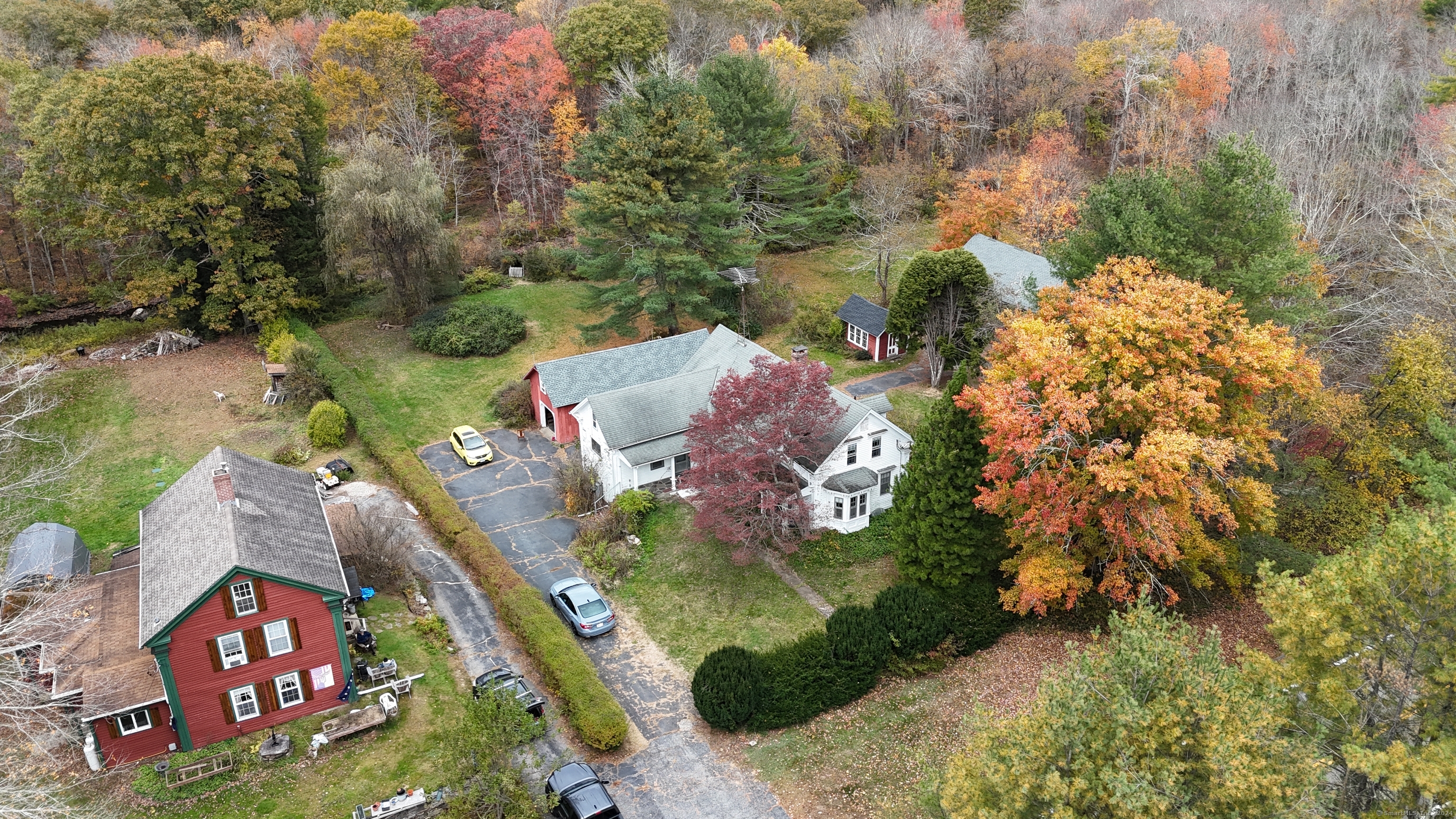 an aerial view of residential house with outdoor space and trees all around