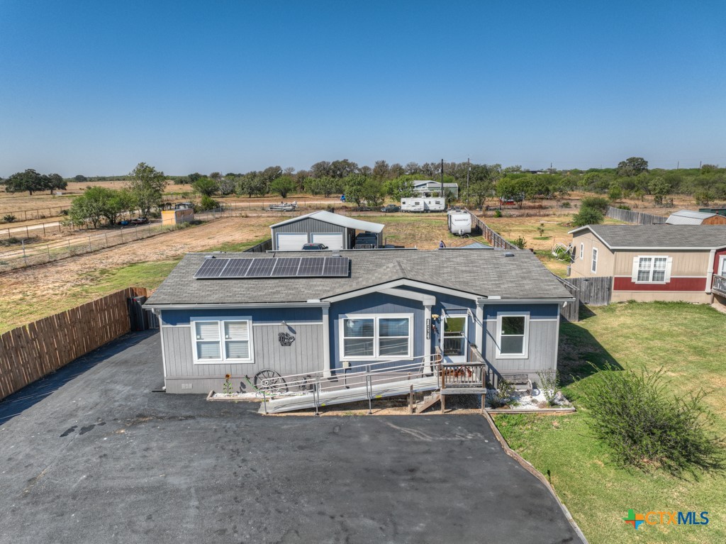 an aerial view of a house with a yard and lake view in back