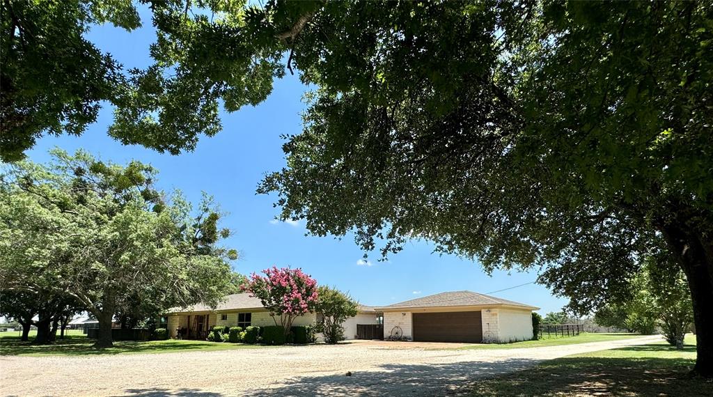 a front view of a house with a yard and trees