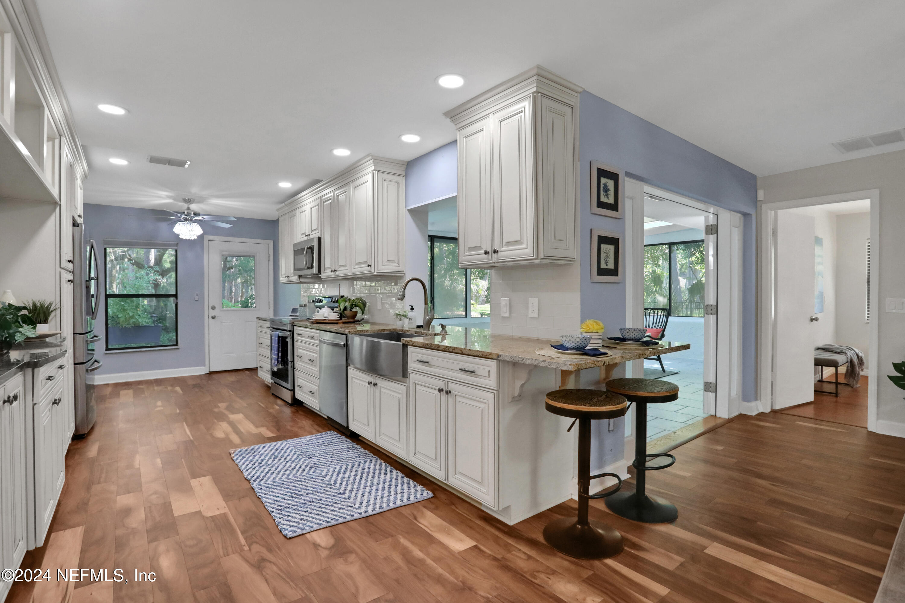 a kitchen with kitchen island granite countertop a sink a counter top space and stainless steel appliances