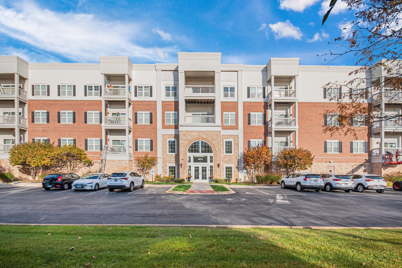 a front view of a building with cars parked