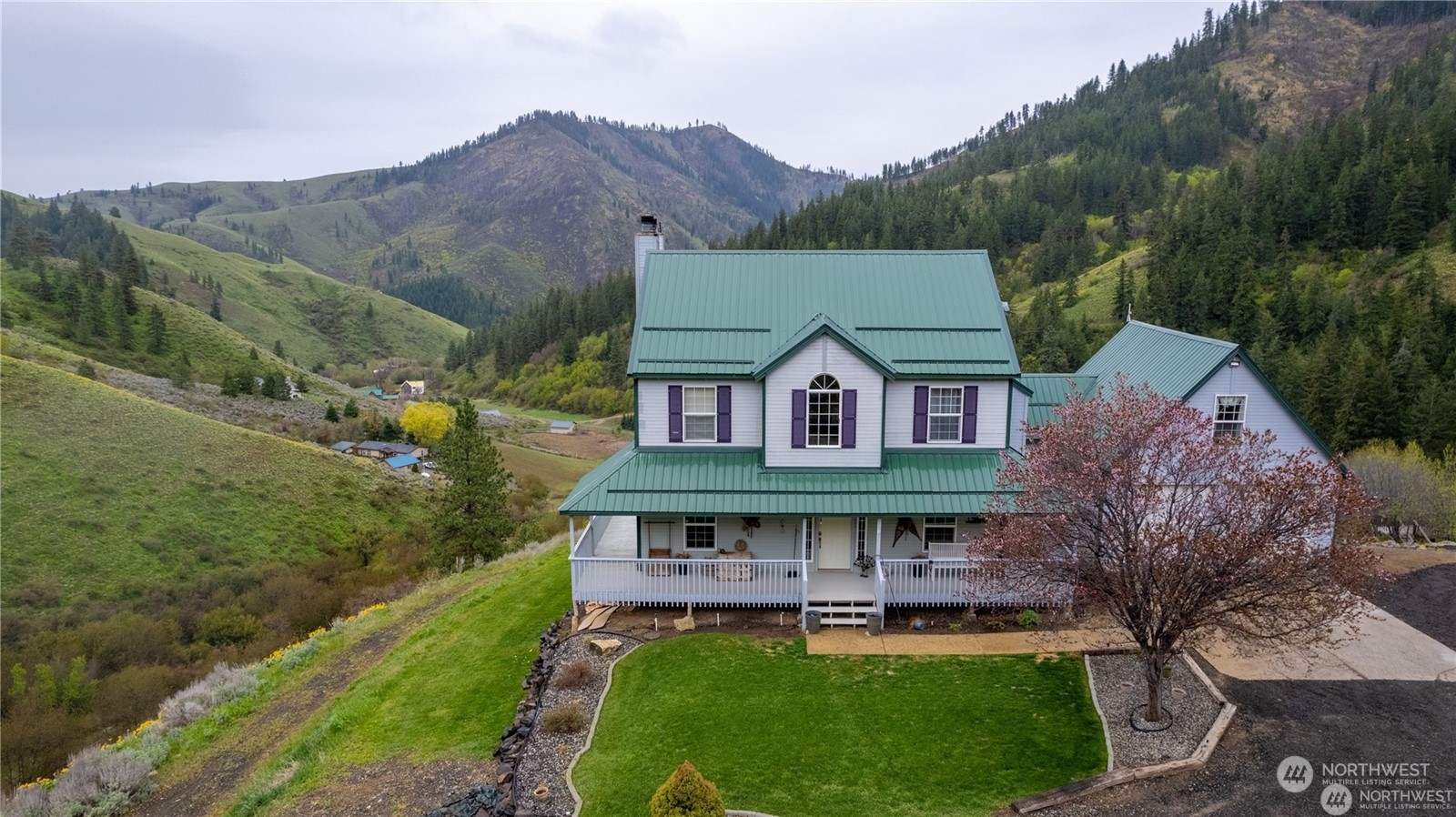 a aerial view of a house with a big yard and large trees