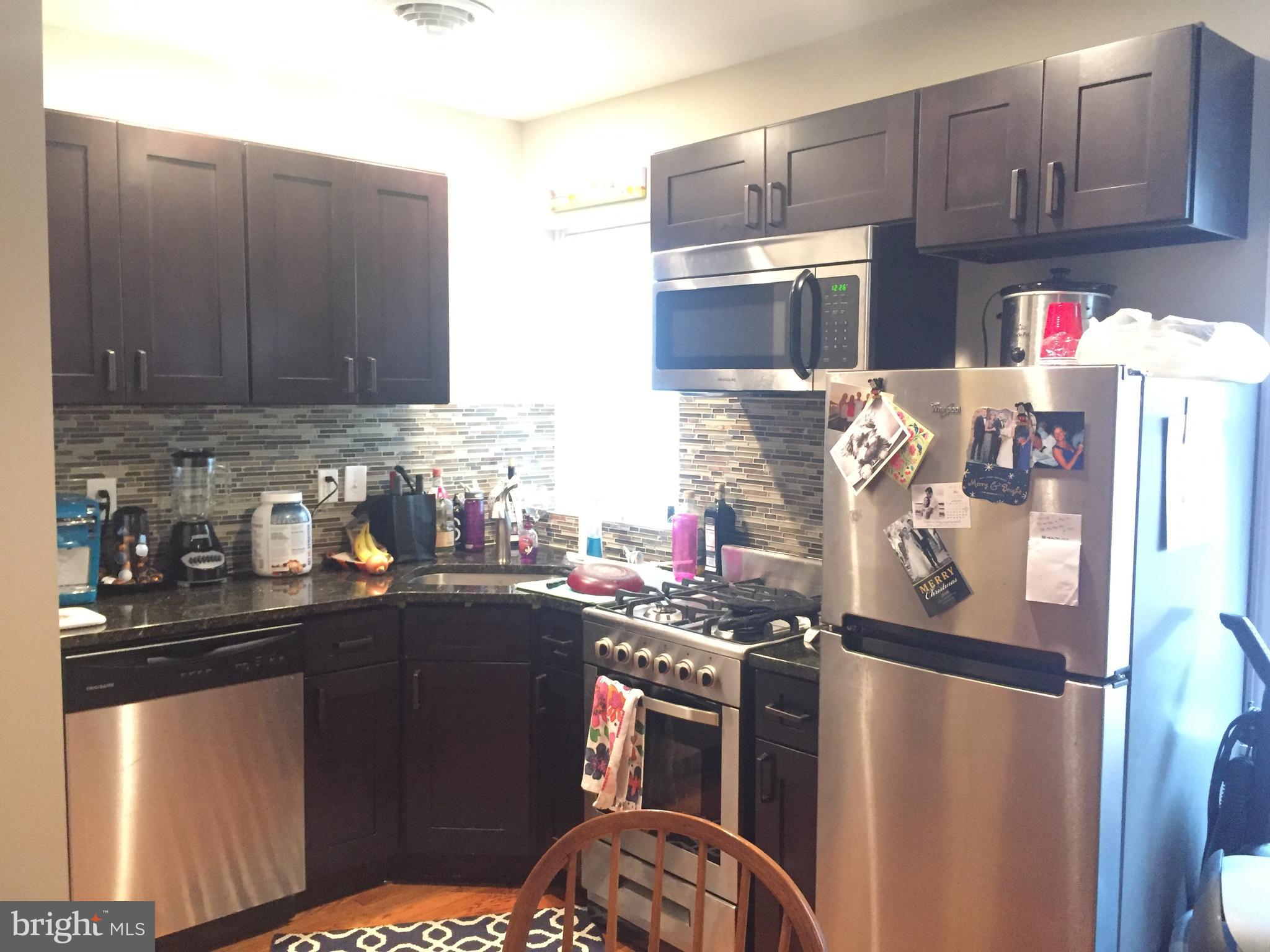 a kitchen with stainless steel appliances granite countertop a refrigerator stove and sink