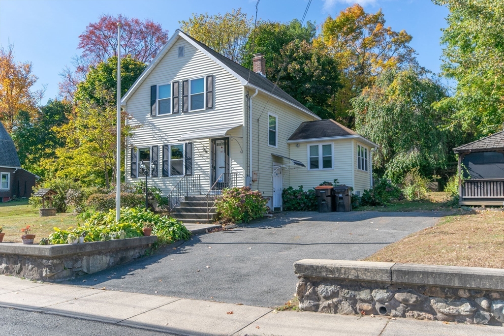 a front view of a house with a yard and potted plants