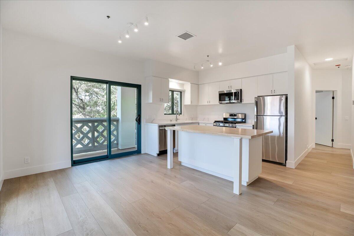 a kitchen with a refrigerator and a stove top oven