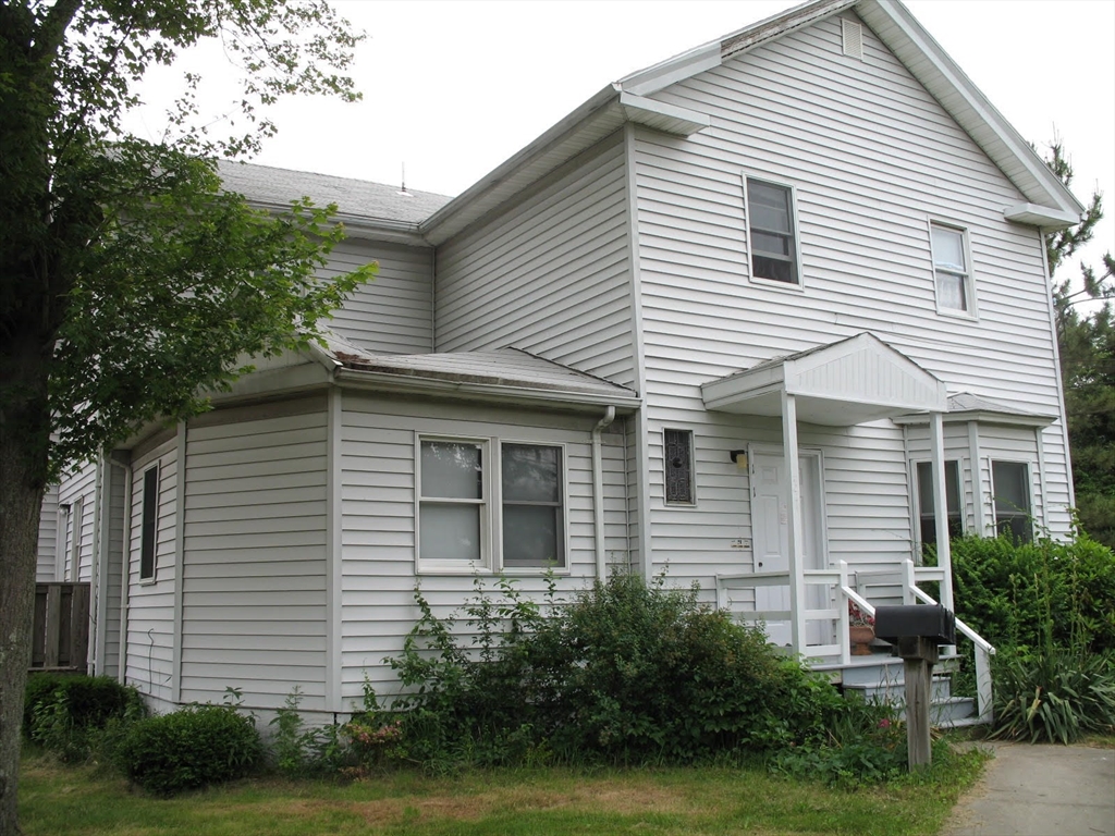 a view of a white house next to a yard