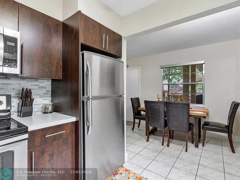 a kitchen with a refrigerator a table and chairs in it