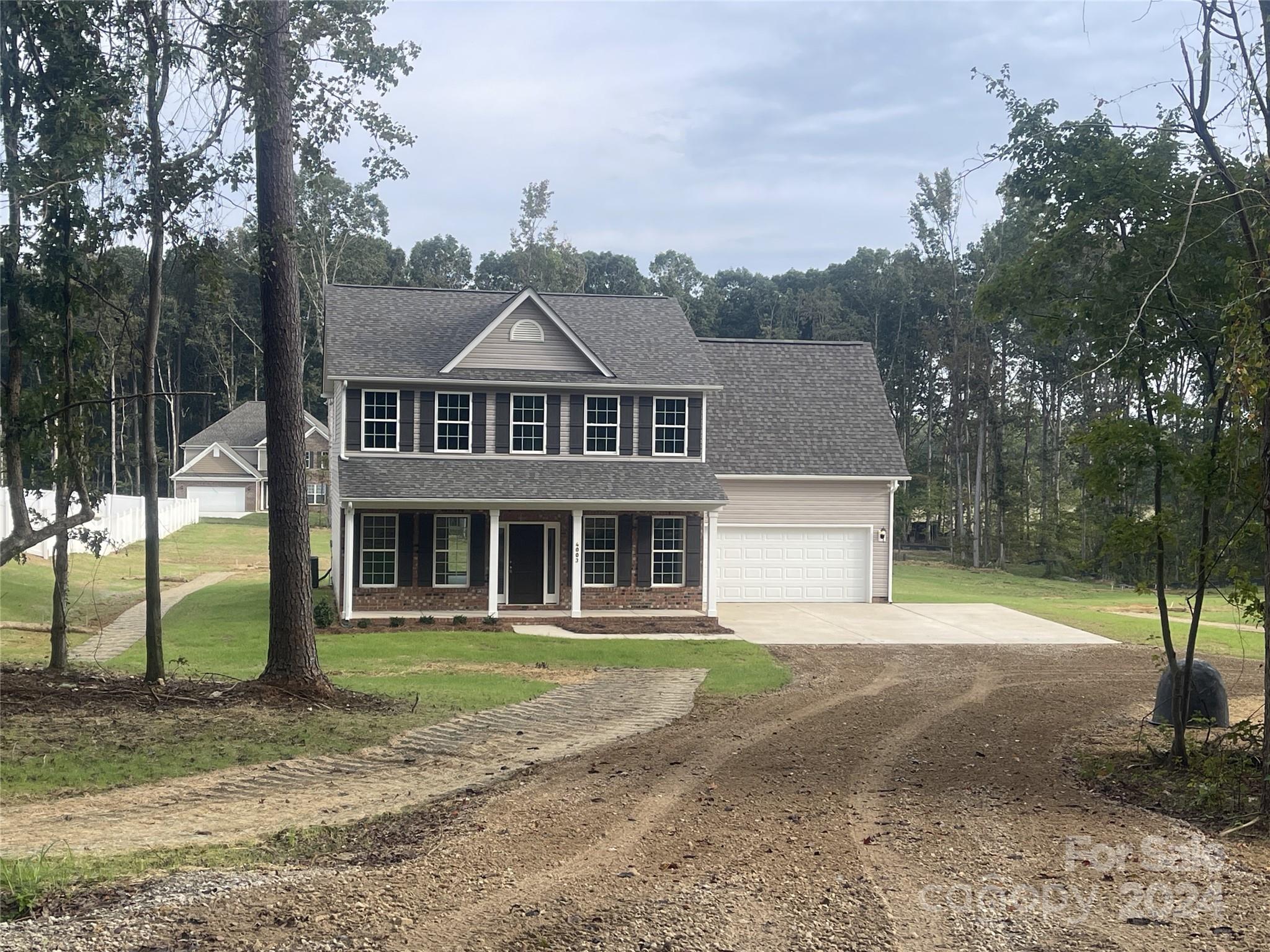 a front view of a house with a yard and trees