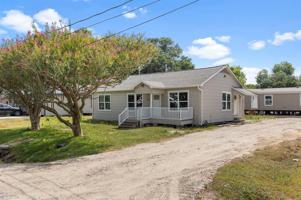 a view of a yard in front of a house with large tree