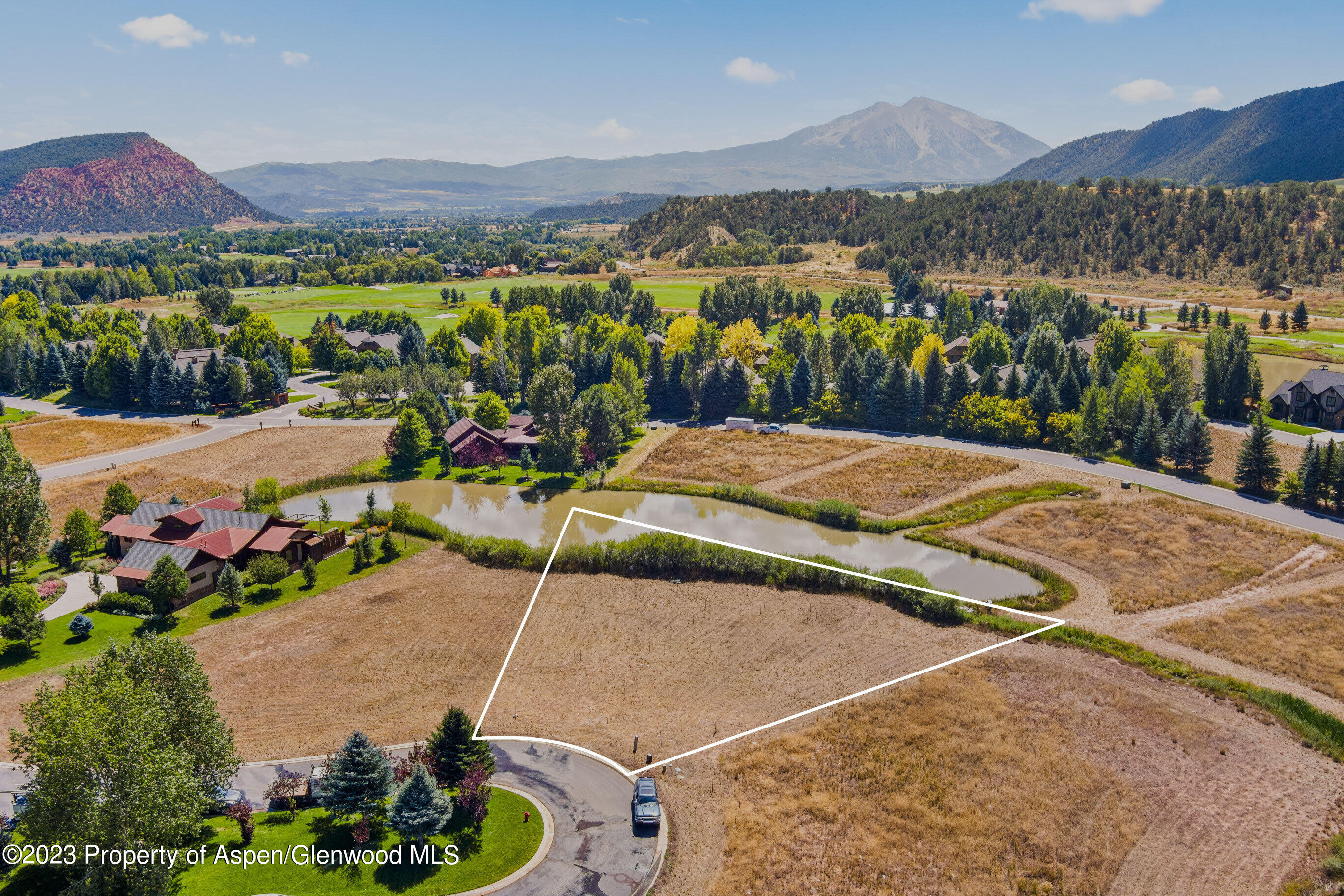 an aerial view of residential houses with outdoor space and seating area