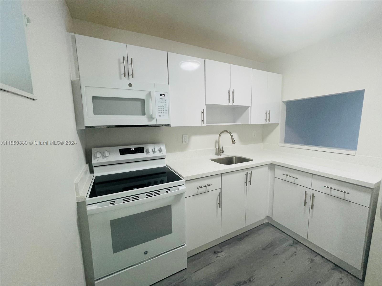 a kitchen with cabinets stainless steel appliances and a sink