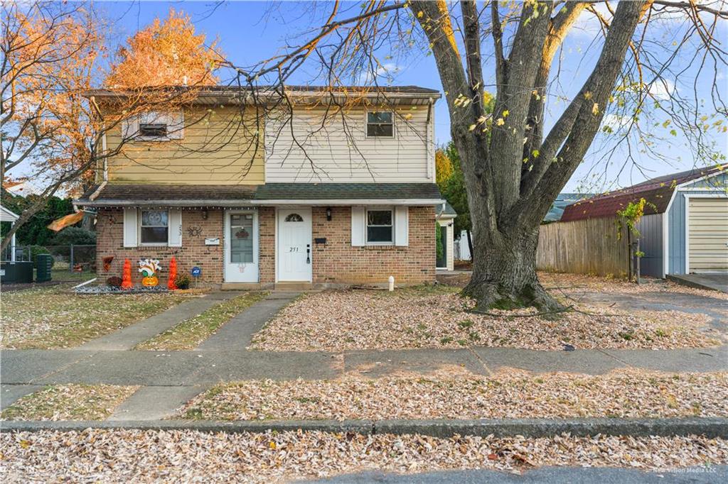 a front view of a house with a yard and trees