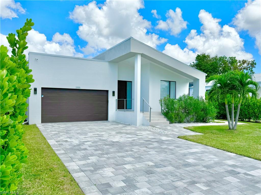 a front view of a house with a yard and a garage