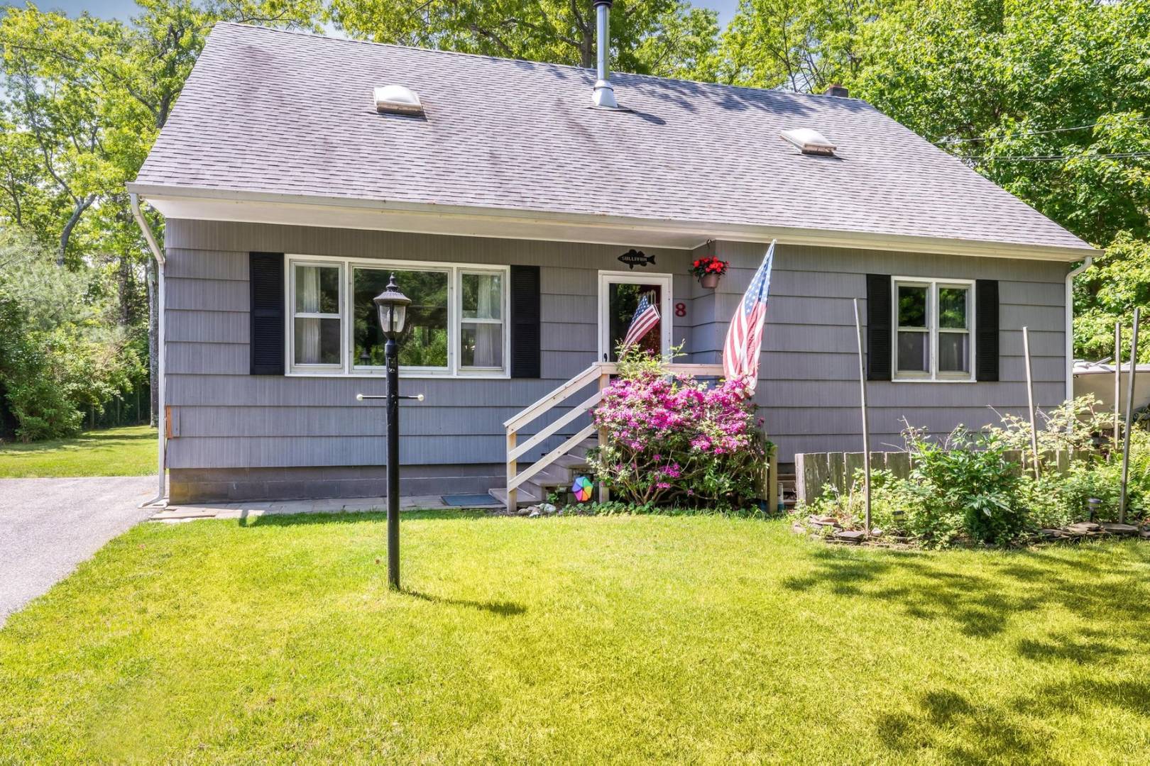 a view of a house with table and chairs next to a yard