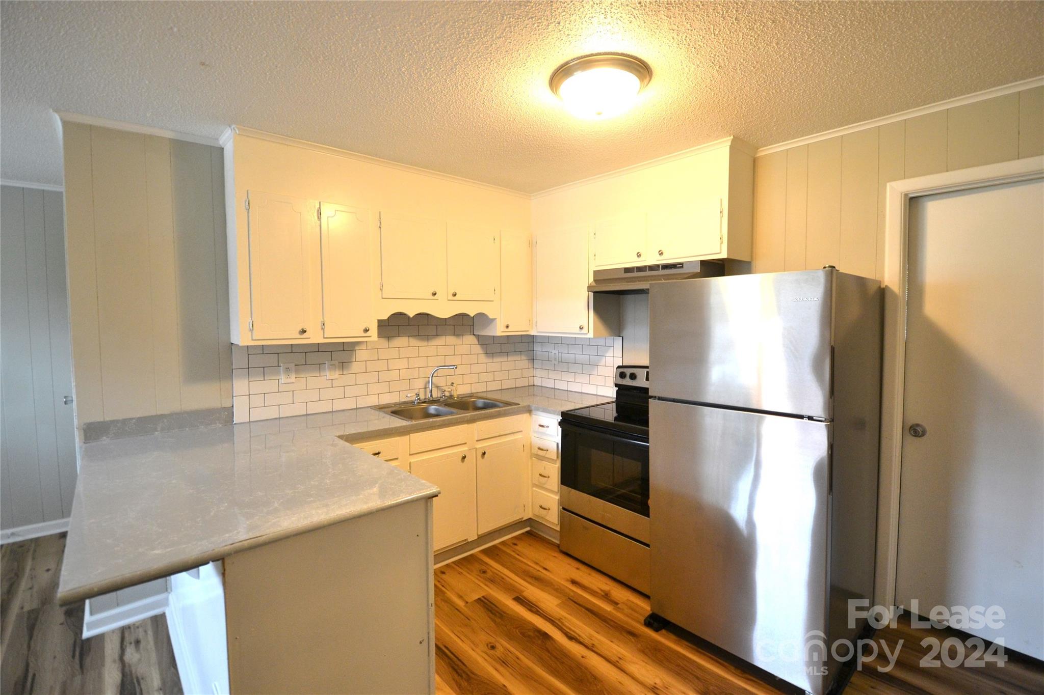 a white refrigerator freezer and a stove sitting inside of a kitchen