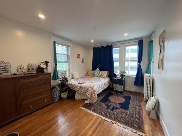 a spacious bedroom with a bed a couch and wooden floor