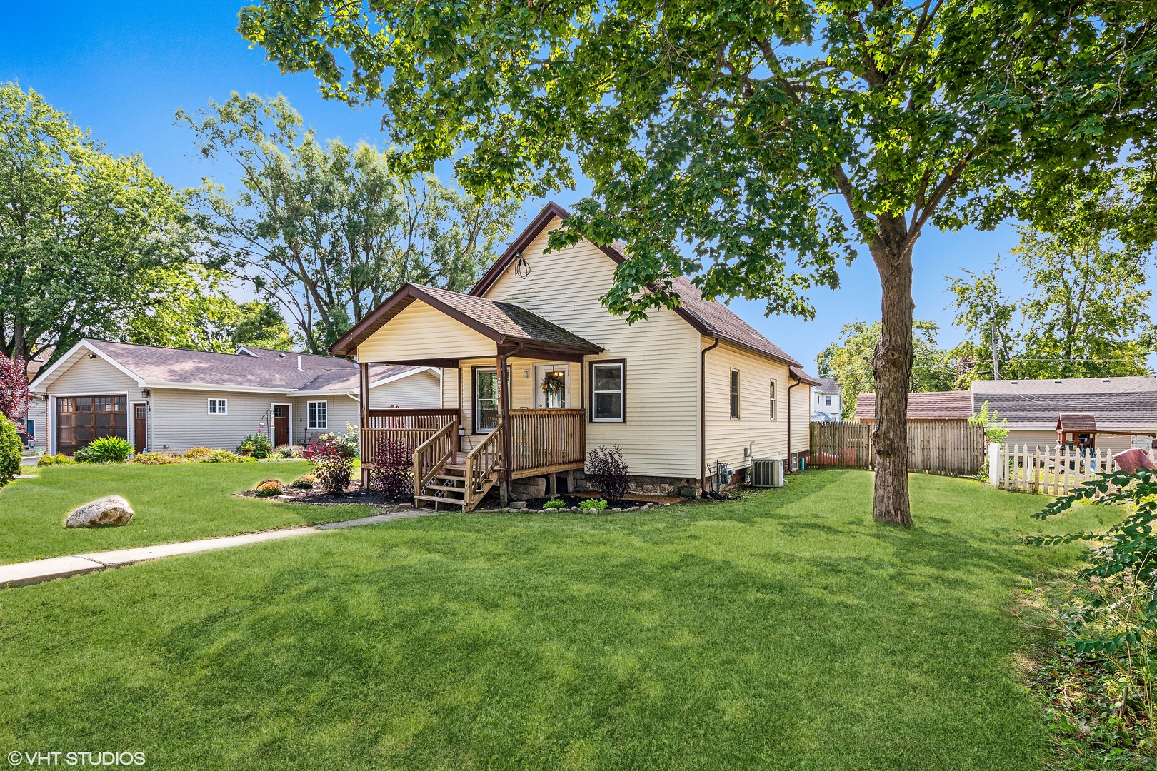 a front view of a house with a yard and trees