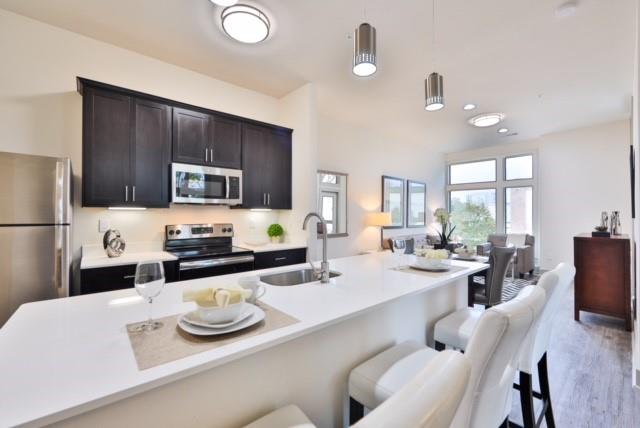 a kitchen with sink refrigerator dining table and chairs