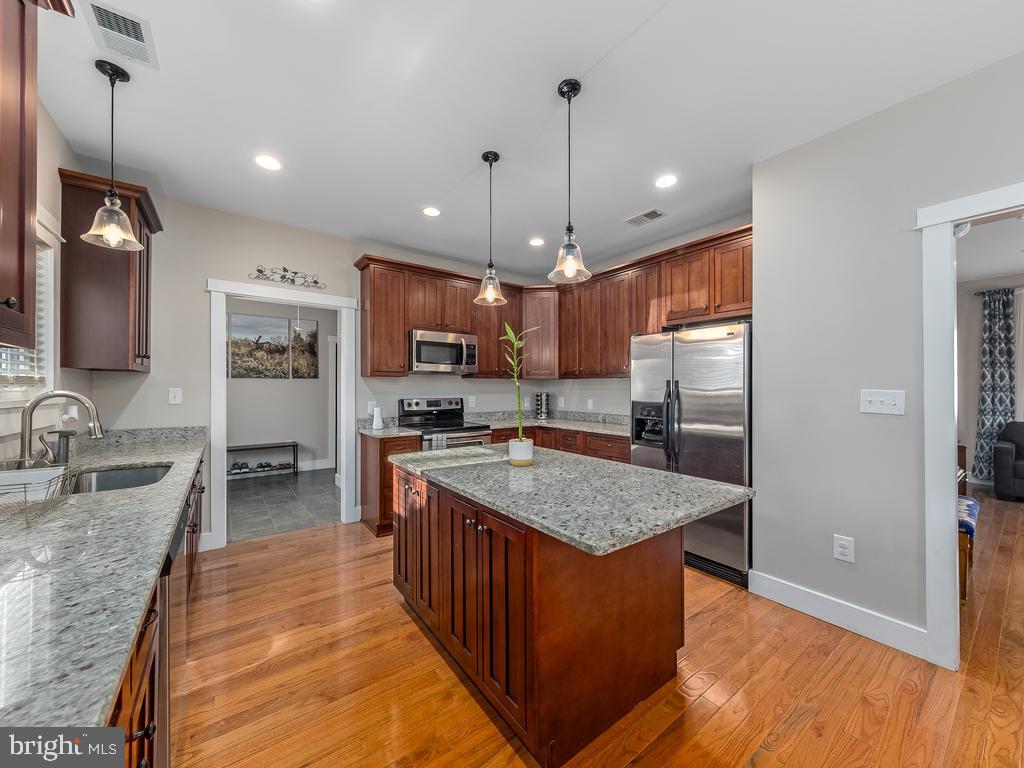 a kitchen with stainless steel appliances granite countertop a sink stove and refrigerator