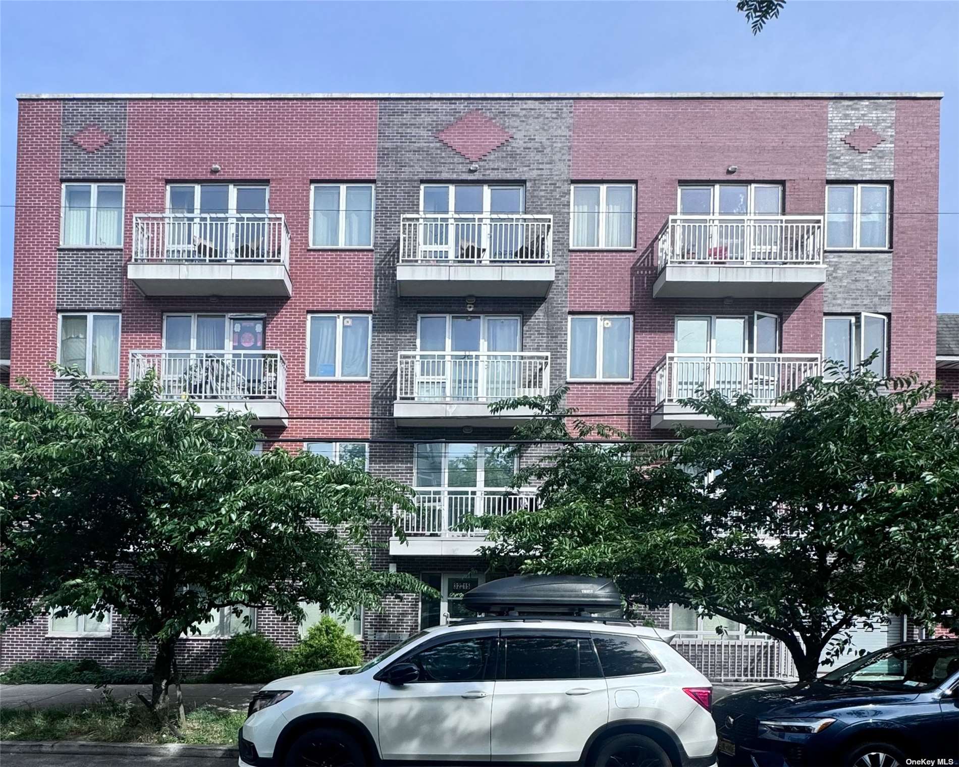 a front view of a residential apartment building with a yard