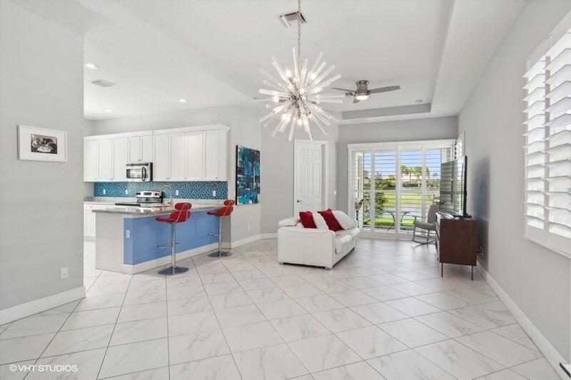 a living room with couches and kitchen view with wooden floor