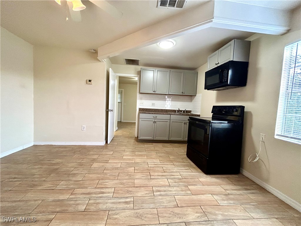 a kitchen with granite countertop a refrigerator and a stove top oven