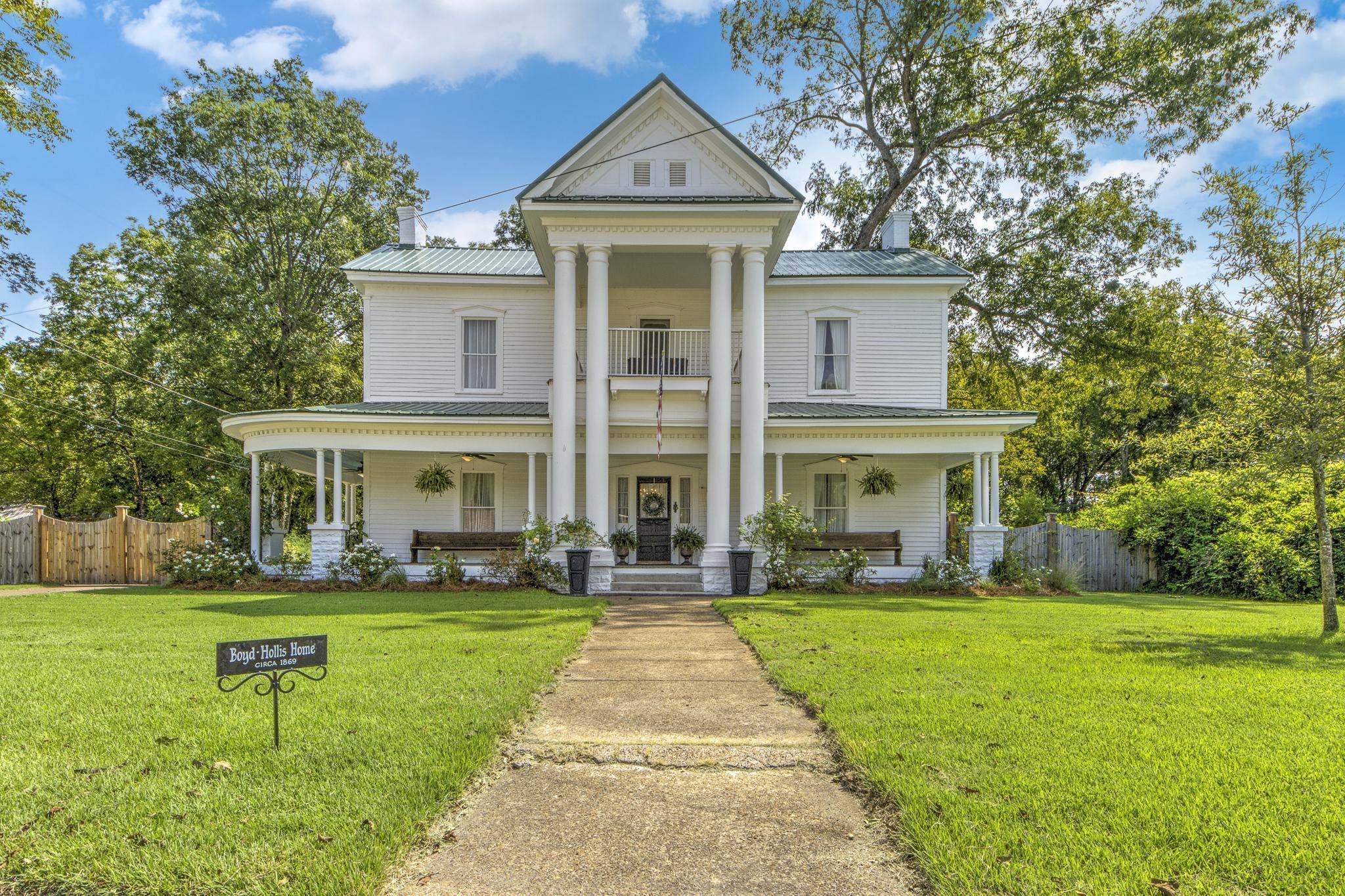 a front view of a house with a yard and trees