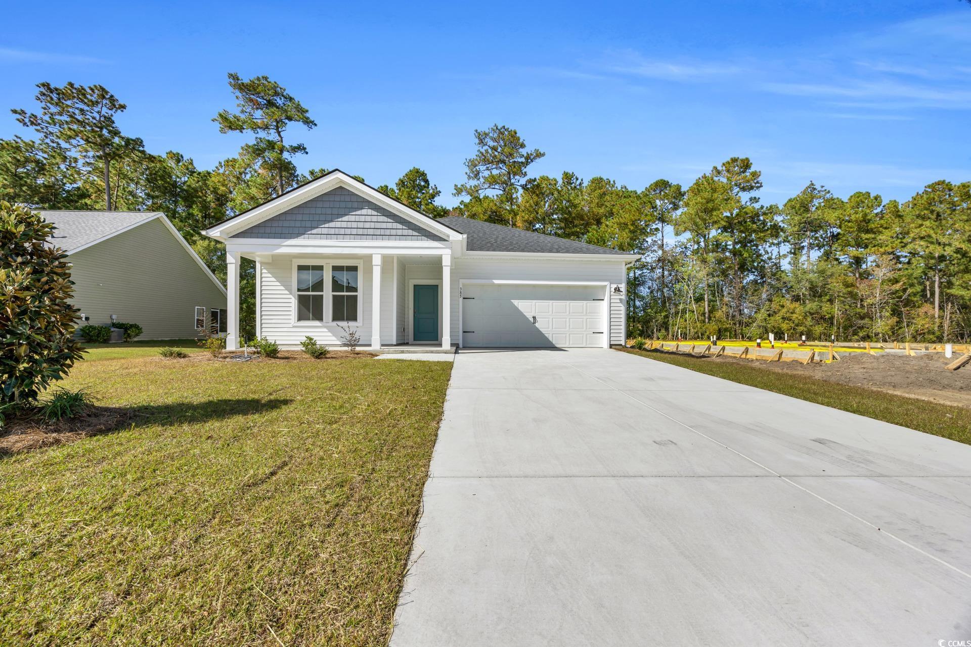 View of front of home with a garage and a front la