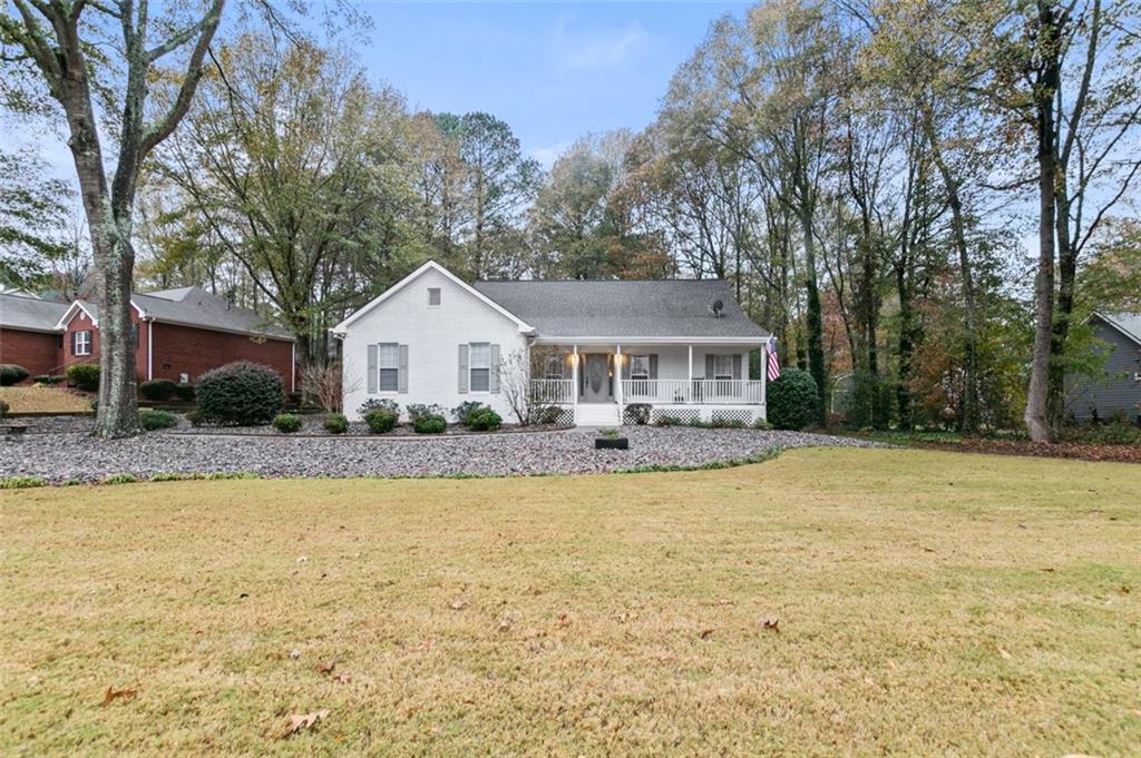 a front view of house with yard and trees in the background