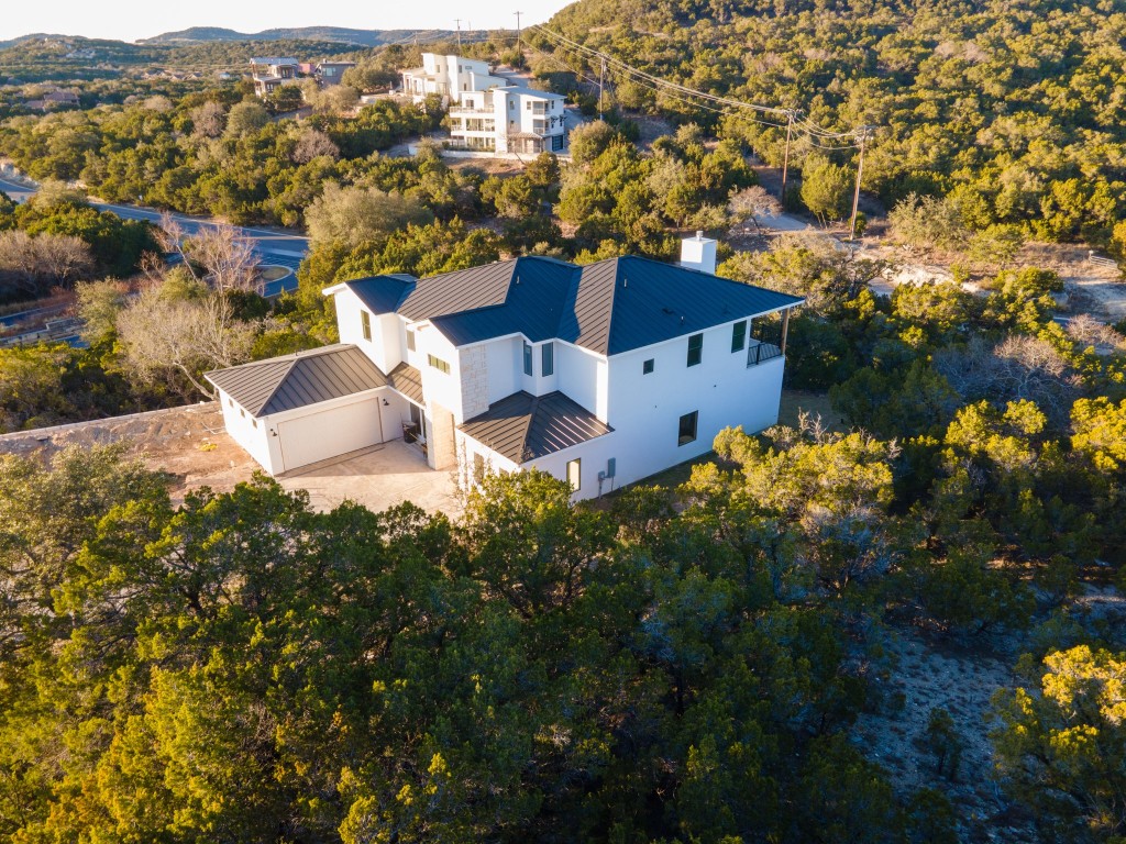 an aerial view of a house with a garden and mountains