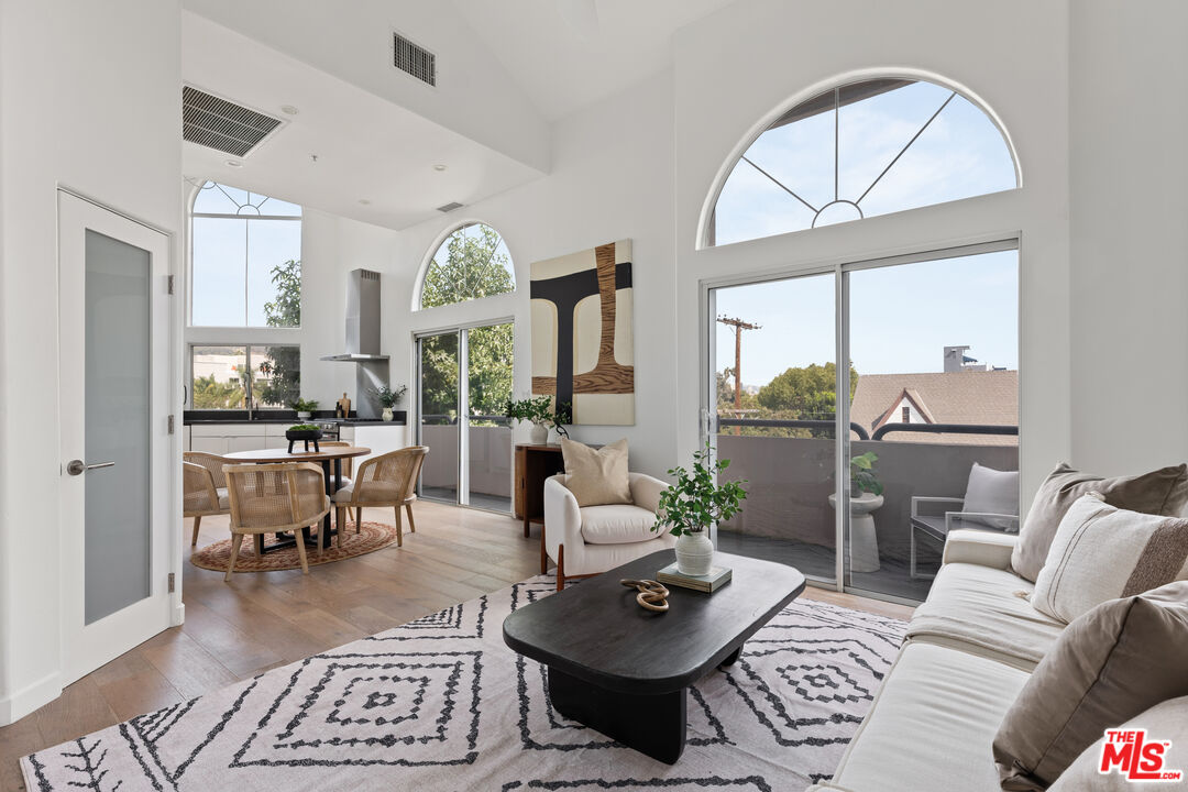 a living room with furniture a large window and a table