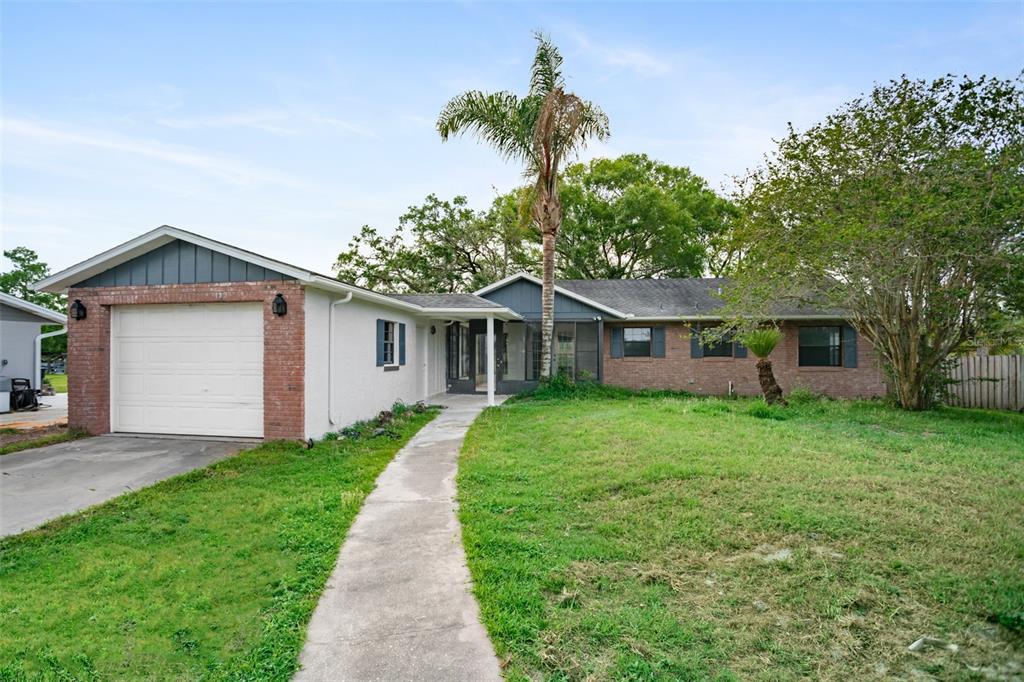 a front view of a house with a yard and trees