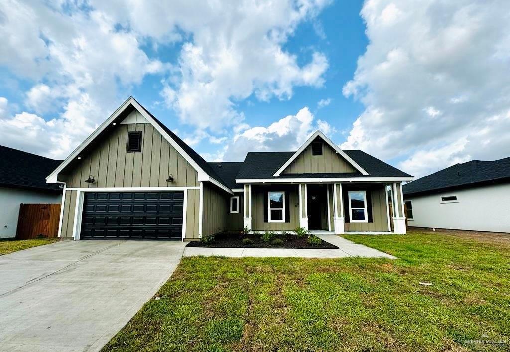 View of front of house with a garage and a front yard