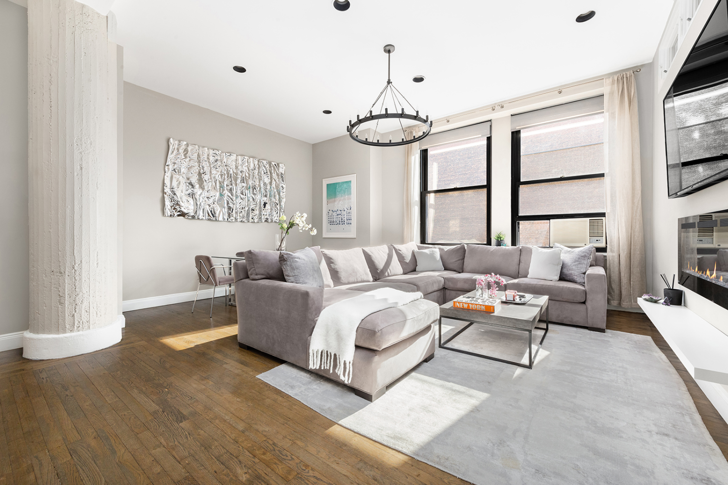 a living room with furniture a large window and a chandelier