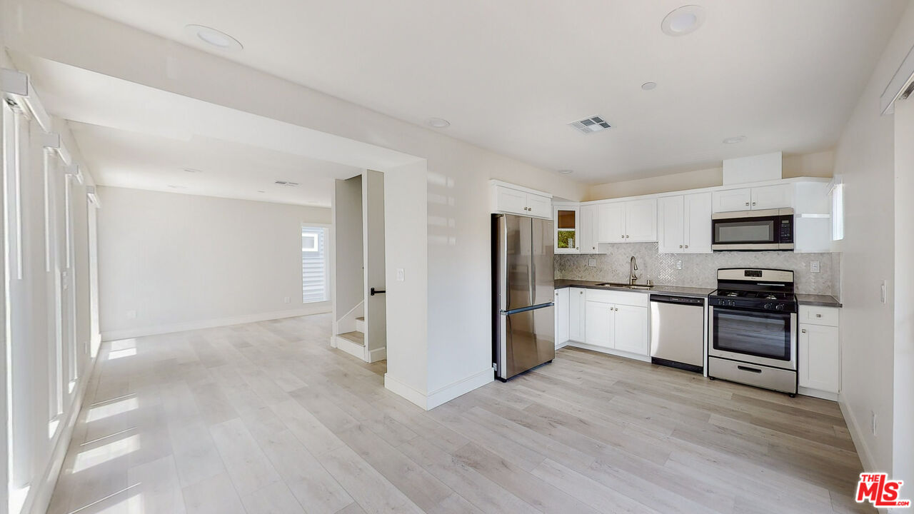 a kitchen with stainless steel appliances a refrigerator and a stove top oven